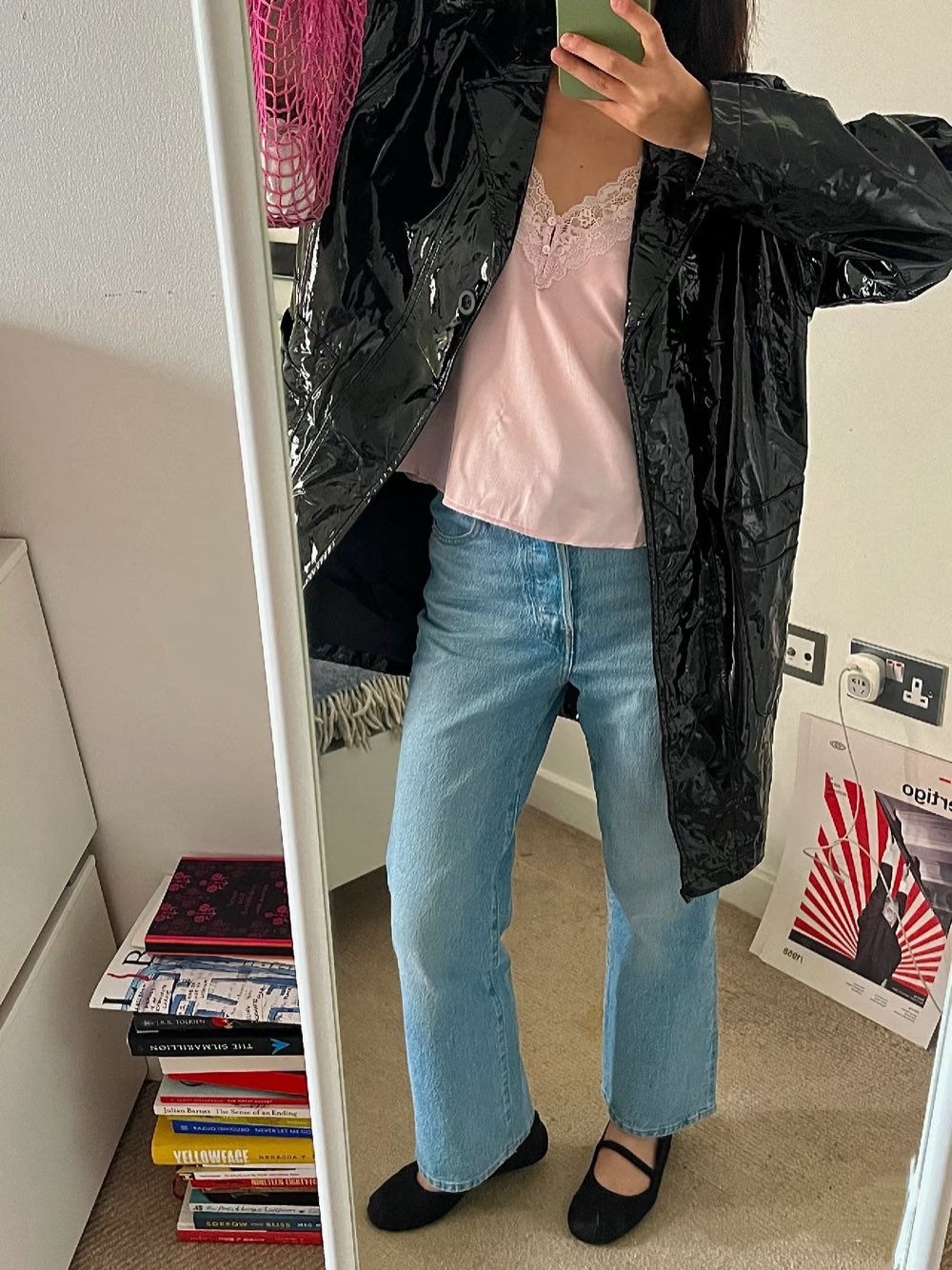 Black patent jacket over a pink lace camisole with light blue jeans and black mary janes