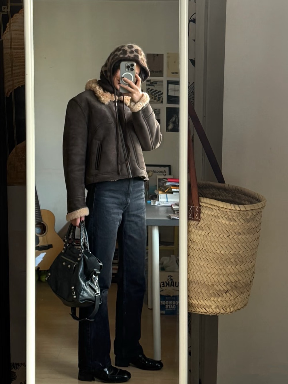 Brown shearling aviator jacket with a leopard print hood, dark denim and black loafers